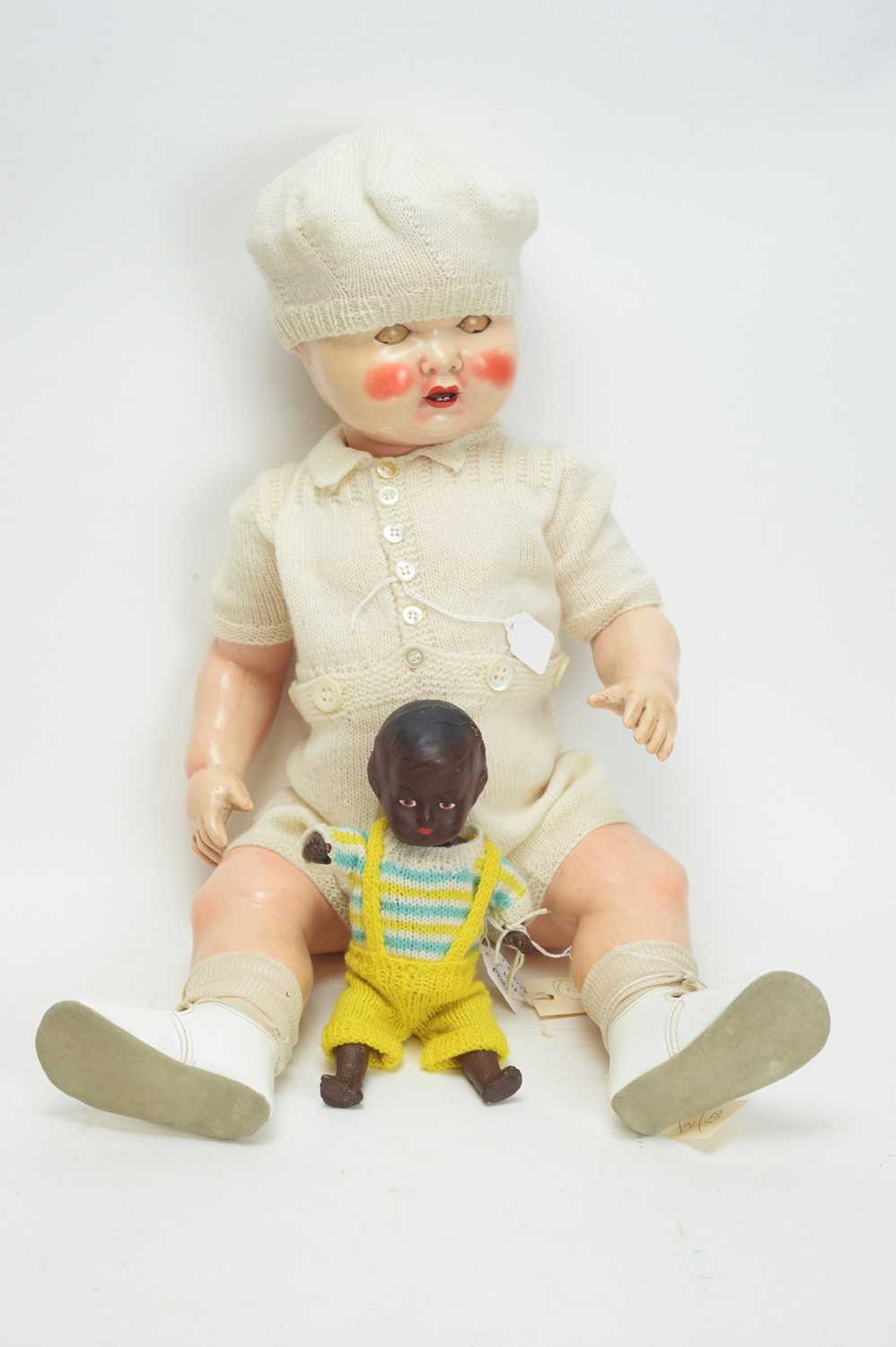 Lot 1047 - A mid 20th Century plastic baby doll; and a black doll.