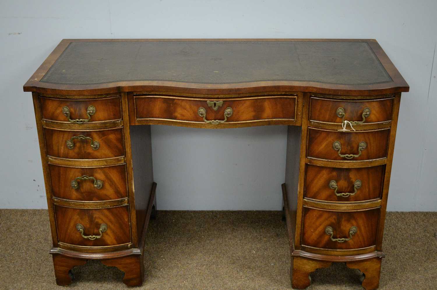 Lot 4 - A Georgian style mahogany serpentine front pedestal desk.