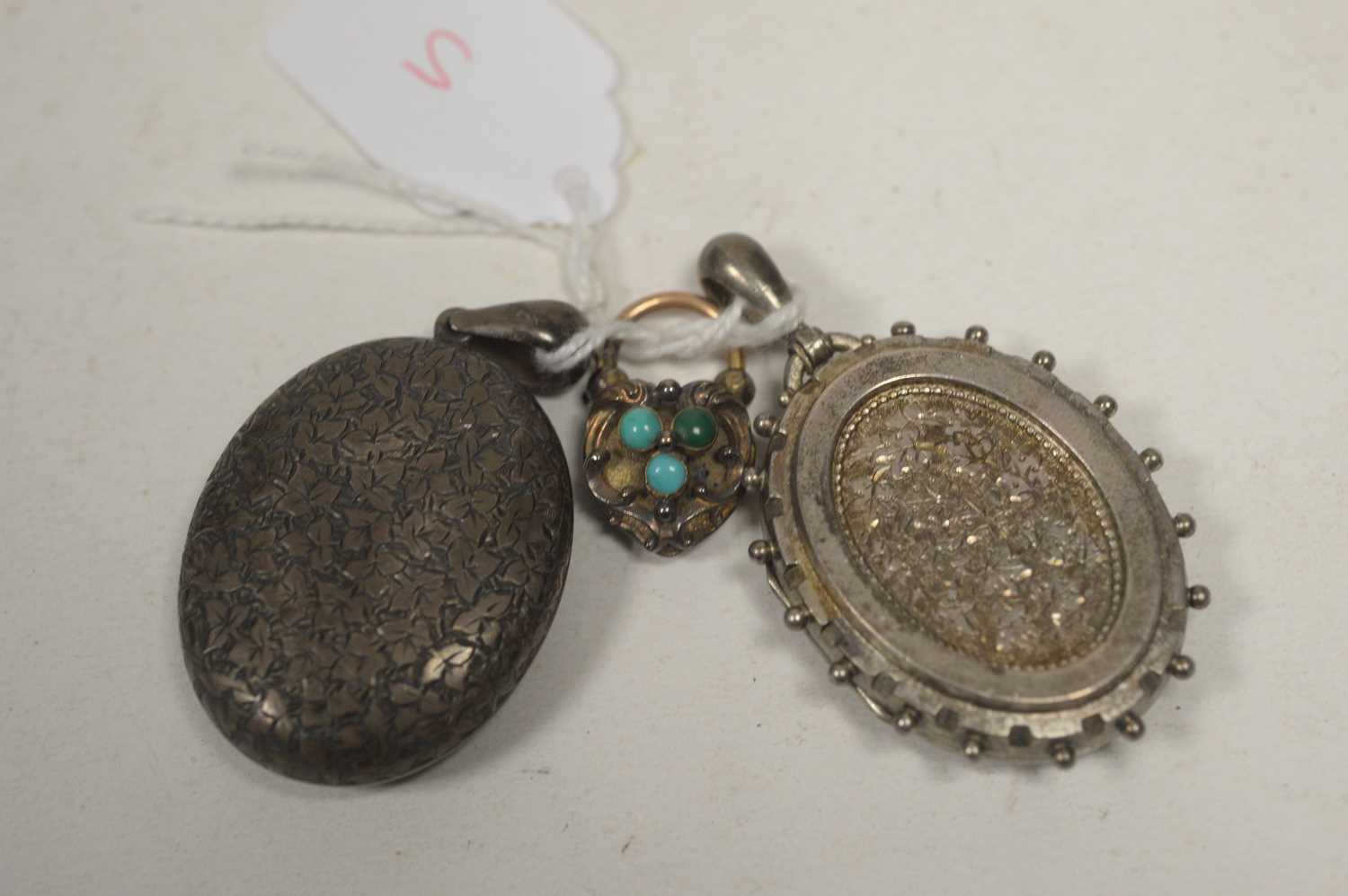 Lot 5 - A heart-shaped locket; and two silver oval lockets.