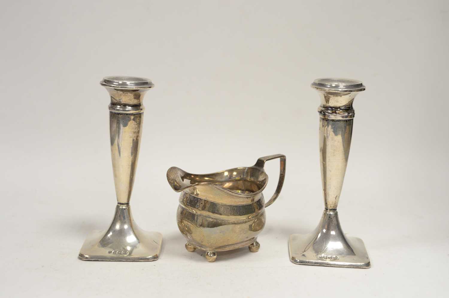 Lot 73 - A pair of silver candlesticks; and a cream jug.
