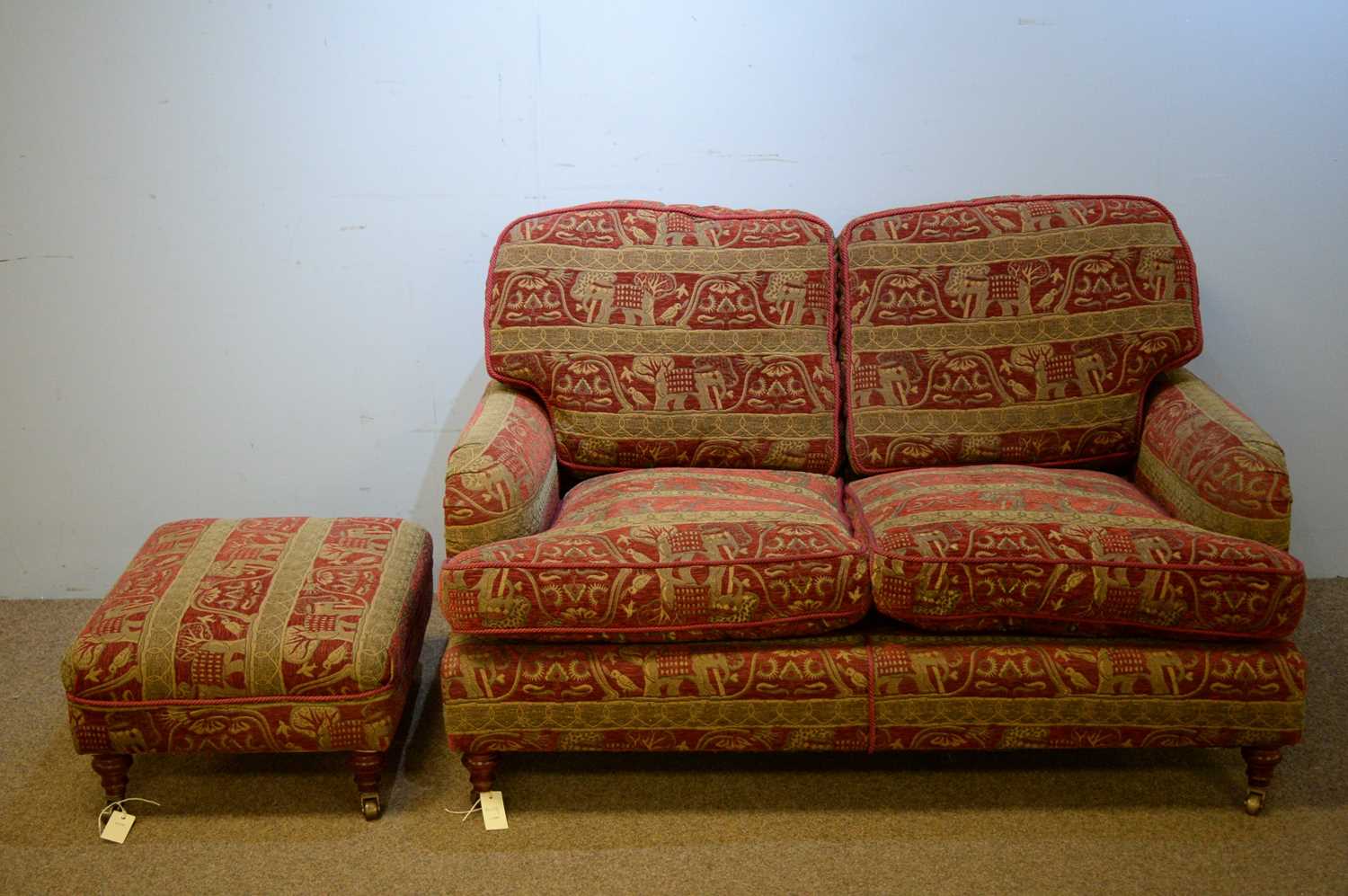 Lot 6 - Two-seater sofa and matching footstool.