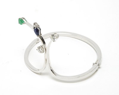 Lot 63 - A diamond, sapphire and emerald set bangle.