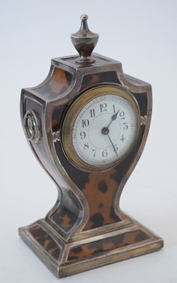 Lot 764 - An Edwardian silver and tortoiseshell mantel timepiece.