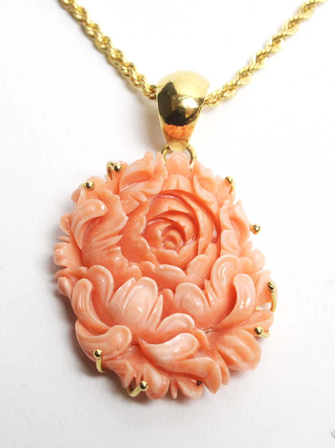Lot 25 - A carved coral pendant on 18ct gold chain