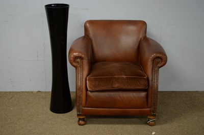 Lot 28 - 20th C brown leather armchair; and a black glass vase.