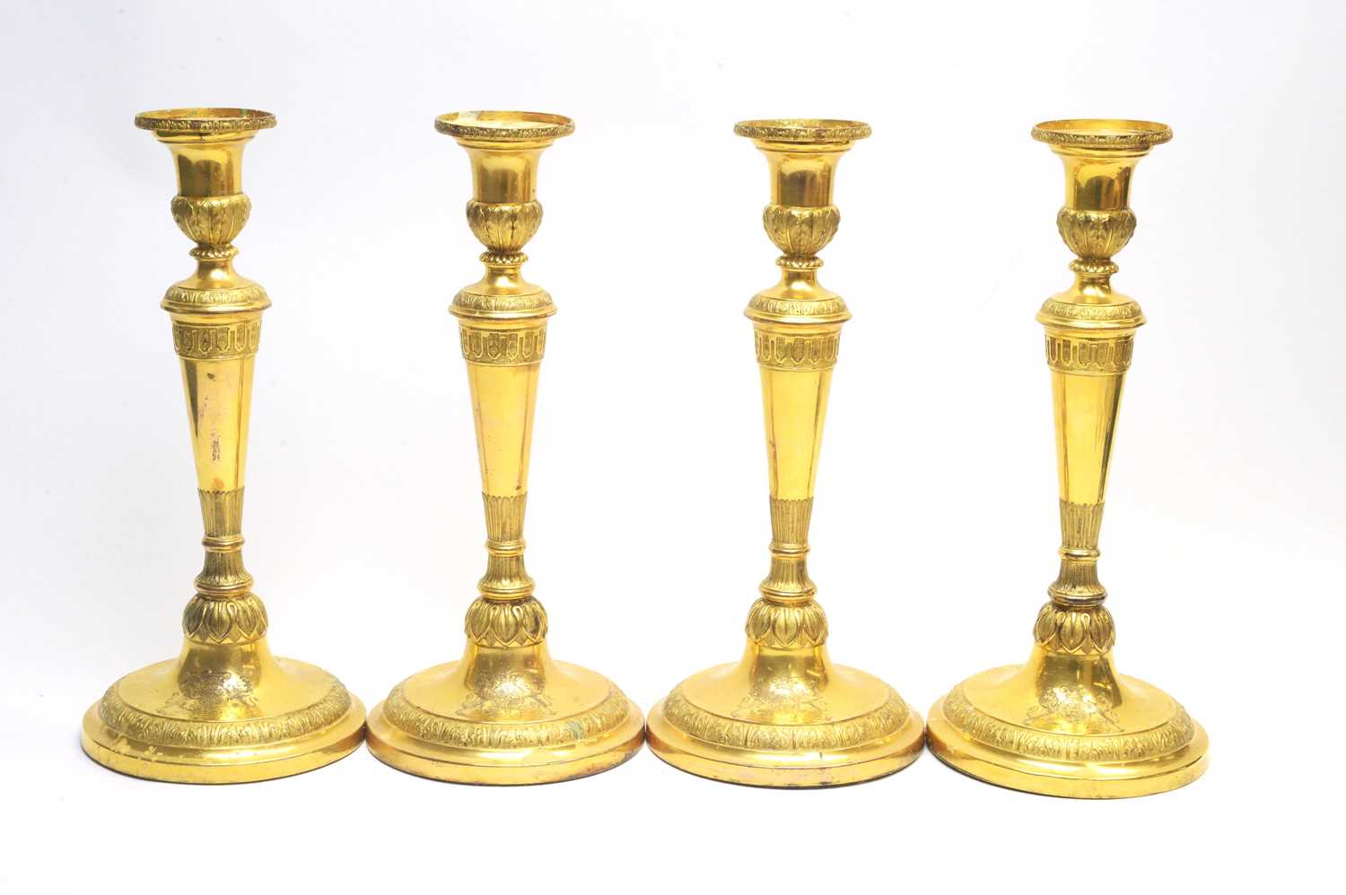 Lot 133 - A set of four Victorian gilt metal candlesticks.