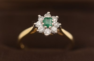 Lot 306 - An emerald and diamond cluster ring.