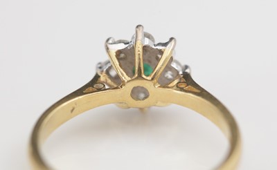 Lot 306 - An emerald and diamond cluster ring.