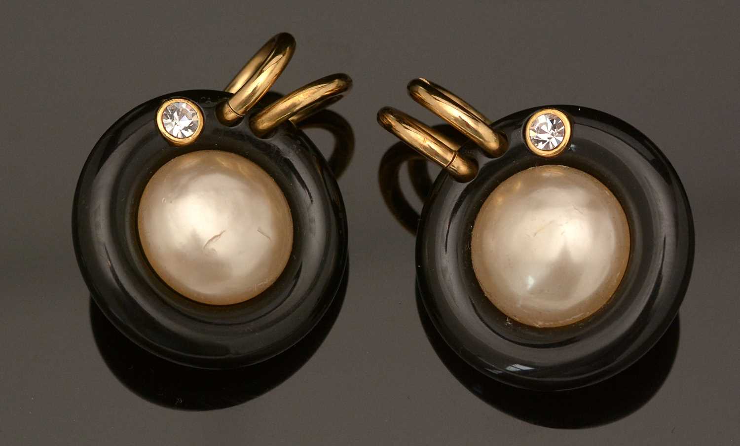 Lot 753 - Chanel: a pair of faux mabe-pearl, black plastic and gilt metal earrings