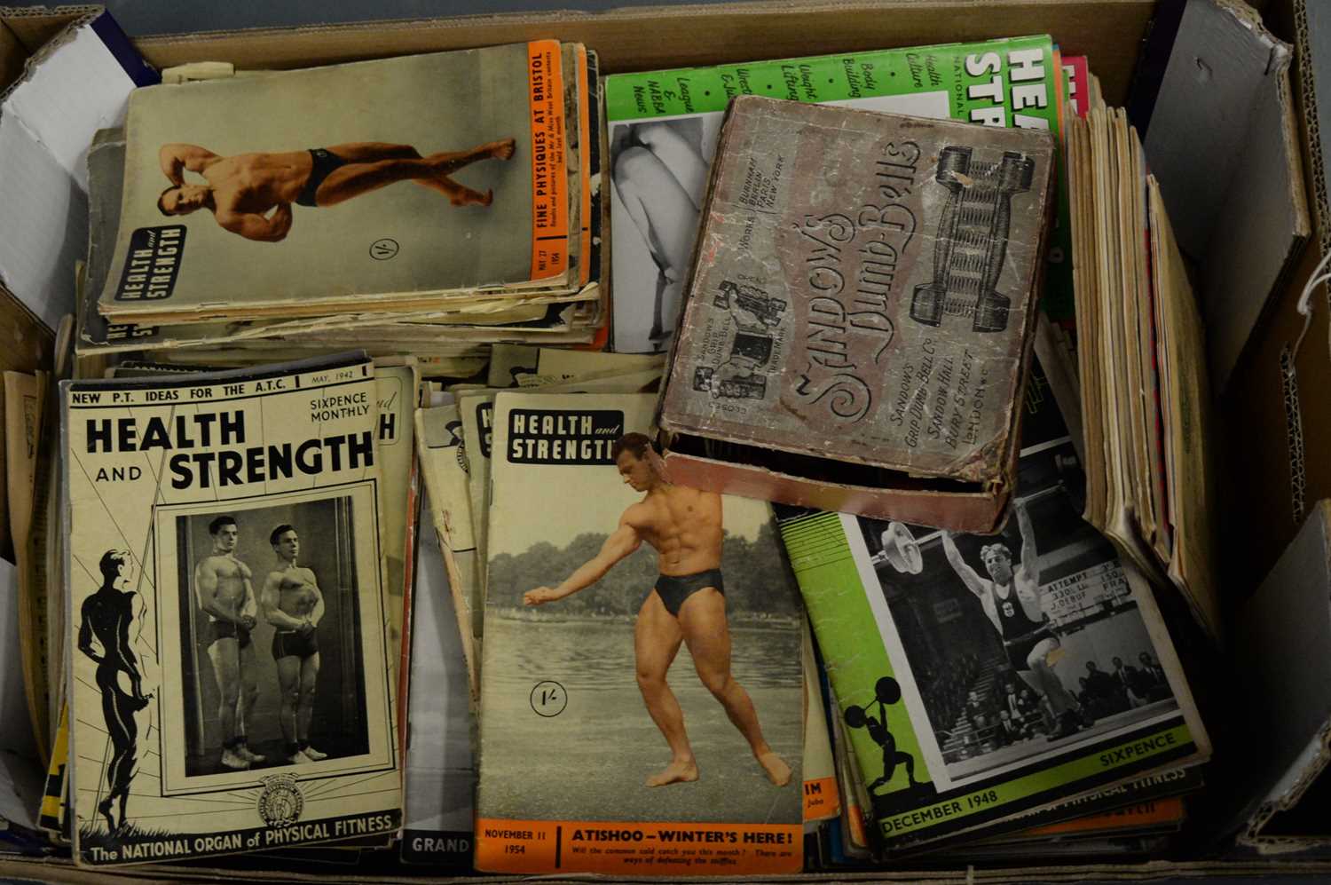 Lot 476 - A collection of 20th century health and fitness magazines and a set of Sandows dumb bells.