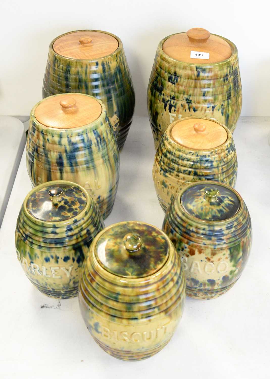 Lot 409 - A set of seven tortoise glazed jars