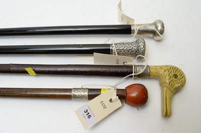 Lot 316 - Two silver topped walking sticks, two others and a stick stand