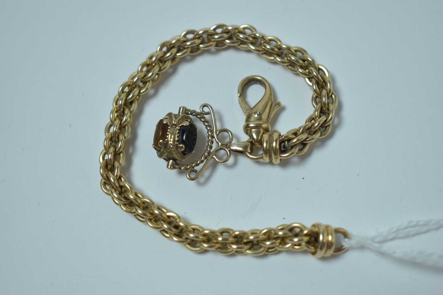 Lot 219 - A yellow metal rope-link watch chain with swivel fob seal