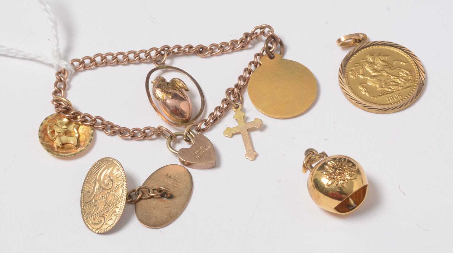 Lot 273 - A child's 9ct gold curb-link charm bracelet suspended with charms.