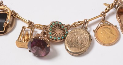 Lot 272 - A yellow-metal charm bracelet suspended with an assortment of charms including sovereigns.