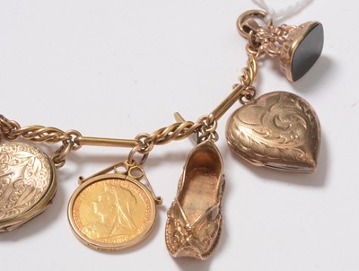 Lot 272 - A yellow-metal charm bracelet suspended with an assortment of charms including sovereigns.