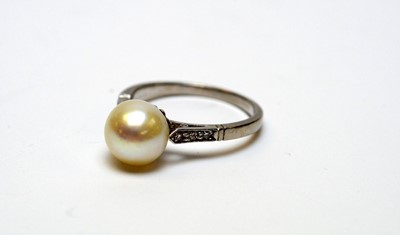 Lot 23 - A high-carat white metal, diamond, and pearl solitaire cocktail ring.