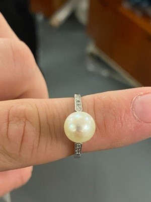 Lot 23 - A high-carat white metal, diamond, and pearl solitaire cocktail ring.
