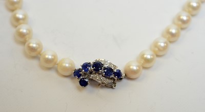 Lot 125 - A pearl necklace with high-carat white metal, diamond, and sapphire clasp.