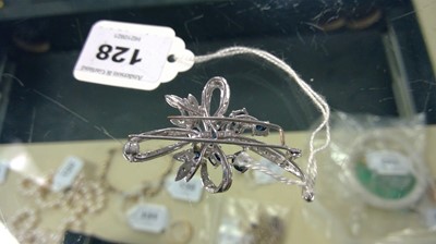 Lot 128 - A high-carat white metal, diamond, and sapphire brooch.