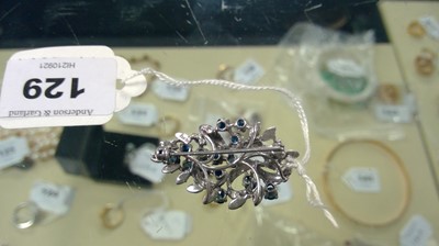 Lot 129 - A high-carat white metal sapphire brooch.