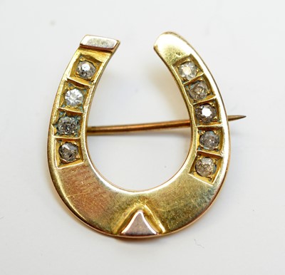 Lot 144 - An antique diamond and yellow metal horseshoe brooch.