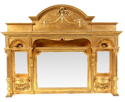 Lot 568 - An ornate gold painted overmantel with an arched and ribbon tied cornice