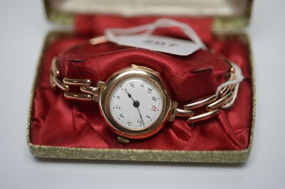 Lot 207 - A lady's 9ct rose gold wristwatch on a yellow-metal flexible bracelet strap.