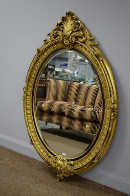 Lot 66 - A large and ornate rococo style gold painted oval mirror