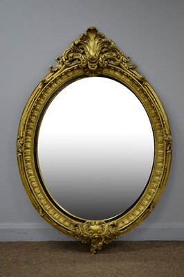 Lot 66 - A large and ornate rococo style gold painted oval mirror