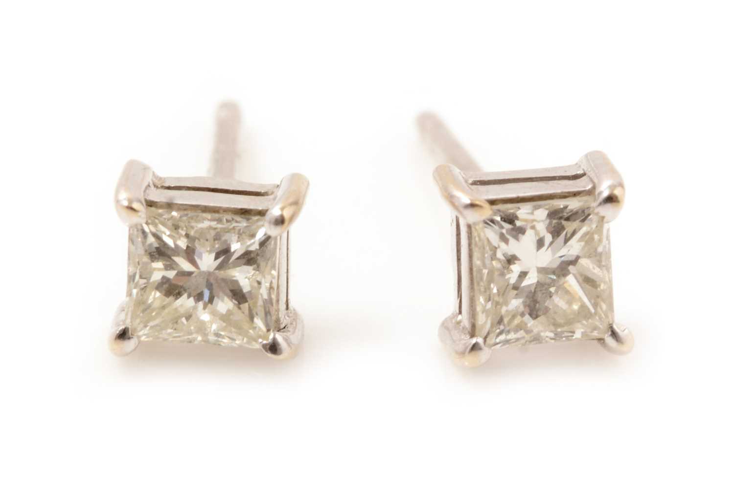 Lot 55 - A pair of princess cut diamond stud earrings