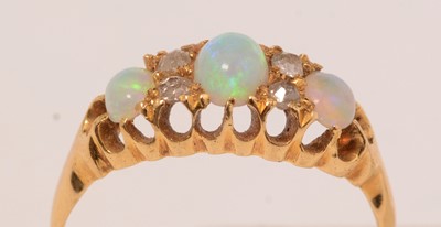 Lot 122 - A three-stone opal, diamond and yellow-metal ring.