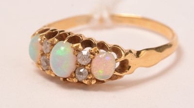 Lot 122 - A three-stone opal, diamond and yellow-metal ring.