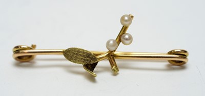 Lot 176 - A 1920s wedding band and a seed pearl and yellow-metal mistletoe brooch.
