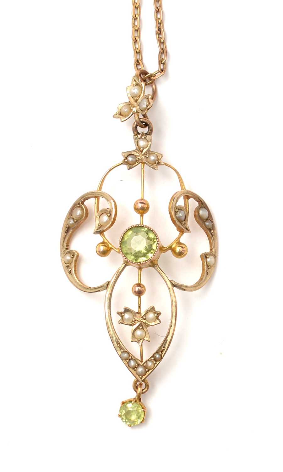 Lot 115 - An Edwardian Art Nouveau peridot and pearl pendant.