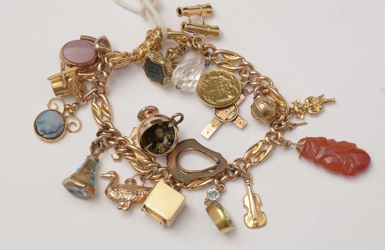 Lot 90 - A yellow-metal charm bracelet and charms.