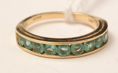 Lot 129 - An 18ct gold and green tourmaline half-hoop eternity ring