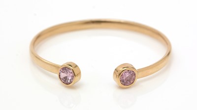Lot 307 - A 9ct yellow gold and pink stone bangle
