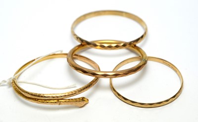 Lot 132 - A gold snake pattern bangle and three others.