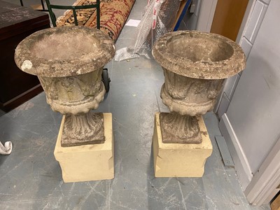 Lot 572 - A pair of stone composite garden urn planters on sandstone bases.