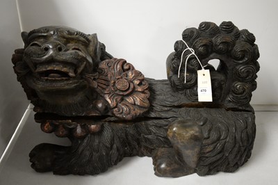 Lot 470 - An early 20th Century Chinese carved wood figure of a foo dog.