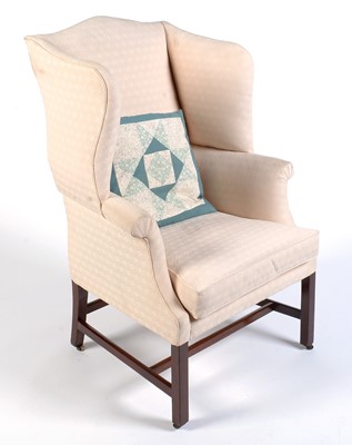 Lot 1050 - A 19th Century wing back armchair upholstered in a cream floral material