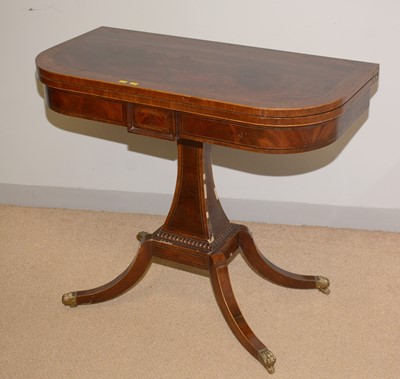 Lot 75 - A late Regency style figured mahogany foldover games table