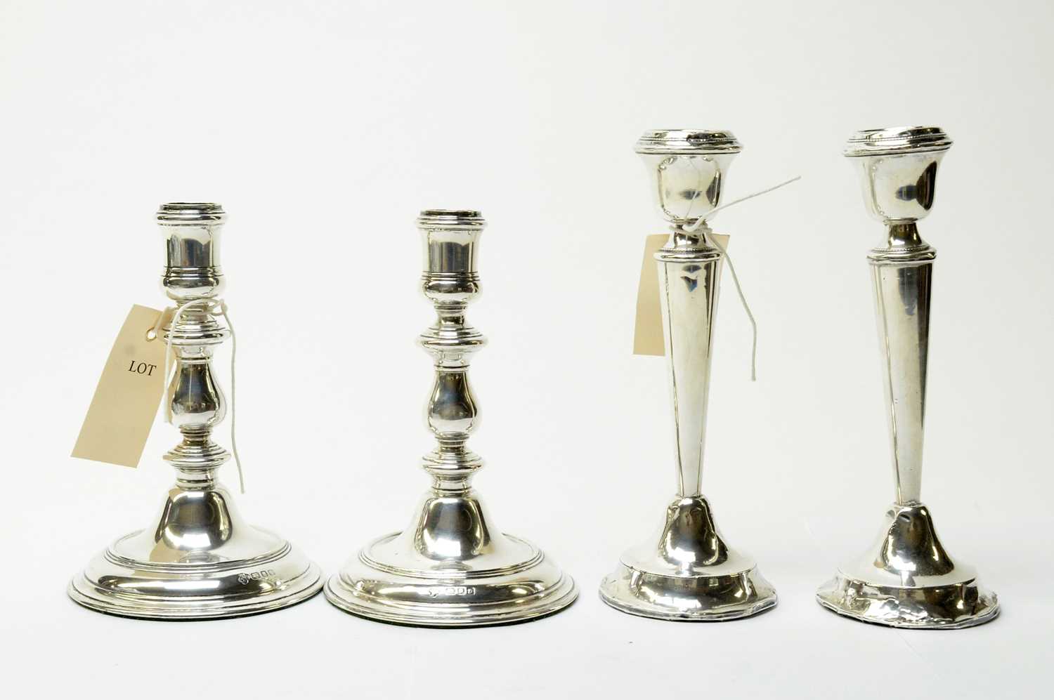 Lot 142 - Two pairs of silver candlesticks
