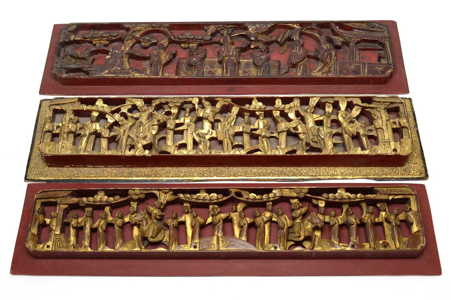 Lot 747 - Three Chinese red and gilt carved wood panels