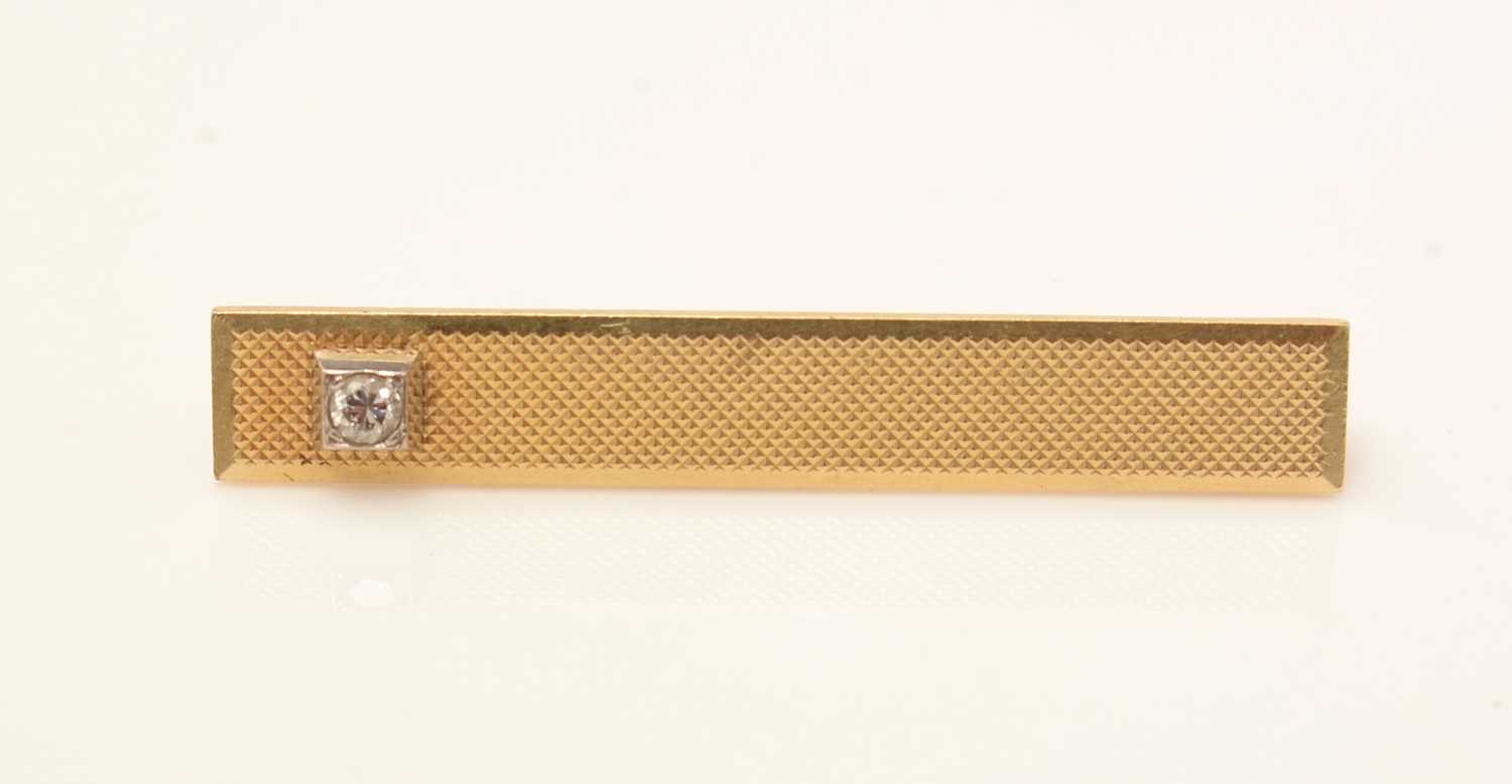 Lot 144 - A diamond set gold tie pin
