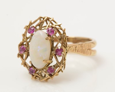 Lot 383 - An opal and ruby nest pattern ring