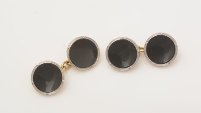 Lot 500 - A pair of onyx set button pattern cufflinks