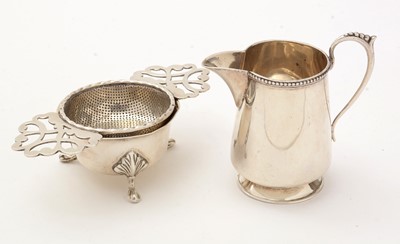 Lot 191 - A silver jug and tea strainer on stand.