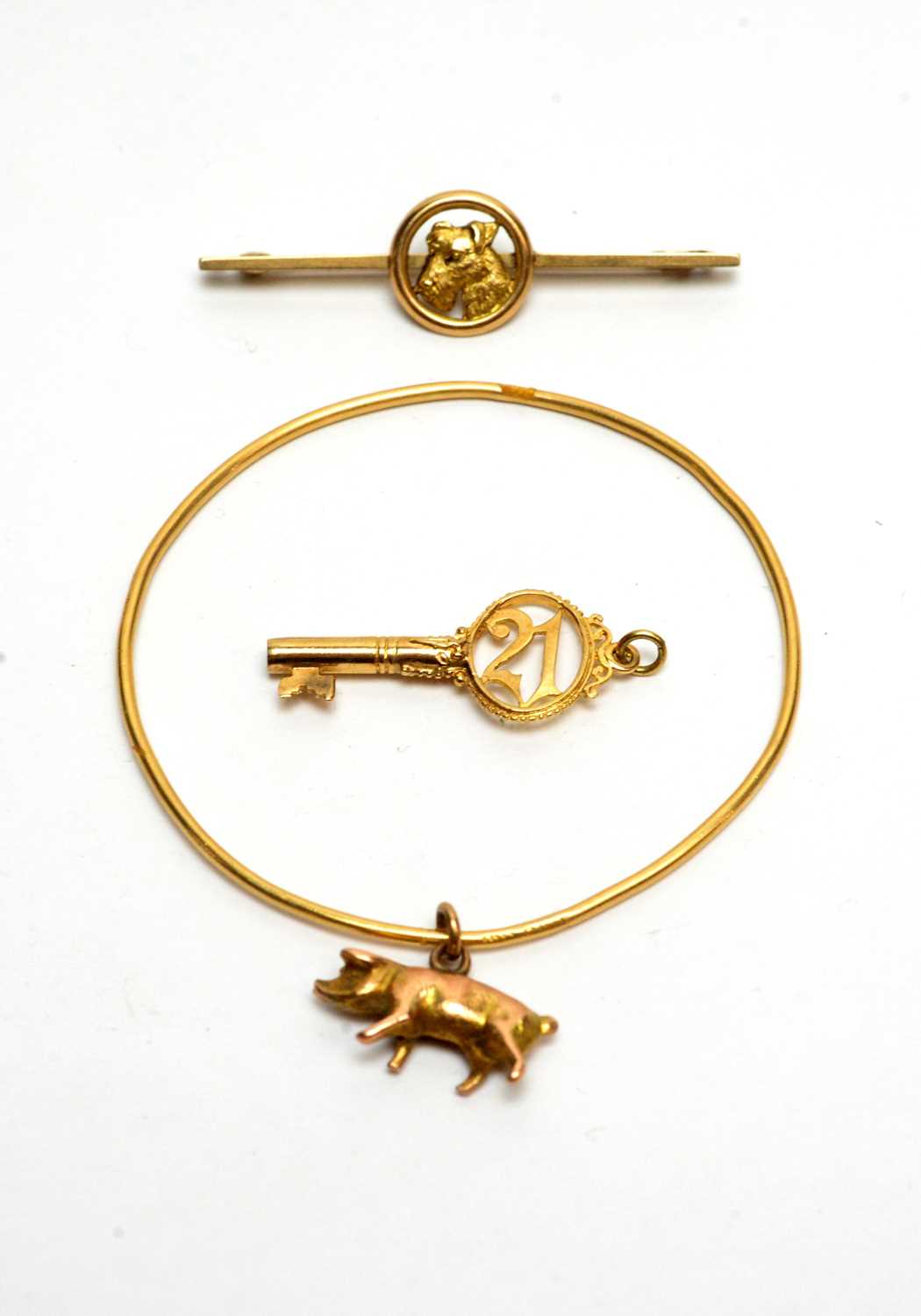 Lot 106 - A yellow gold bangle, a brooch and a pendant